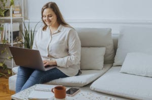 Smiling Plus Size Woman Working on Her Laptop Computer at Home