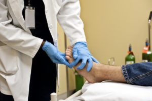 A patient getting treatment from a foot and ankle pain doctor.