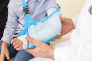 Close up of male doctor checking hand of little patient. People with health care concept