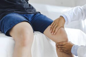 Professional orthopedist examining the little patient's leg in the clinic