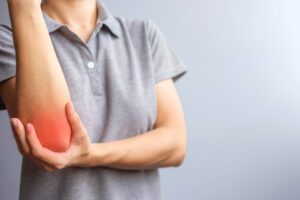 Woman having elbow ache due to tennis elbow
