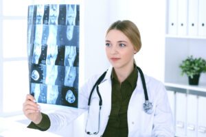 orthopedic surgeon examining x-ray picture near window in hospital