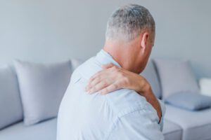 Man suffering from rotator cuff causing him shoulder pain at home.